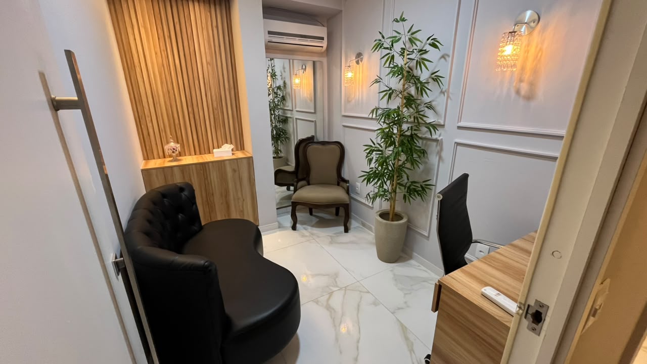 Sala Turmalina – ambiente mobiliado com sofá, poltrona e mesa de atendimento